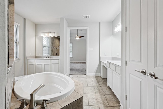 bathroom featuring ceiling fan, vanity, and tiled bath