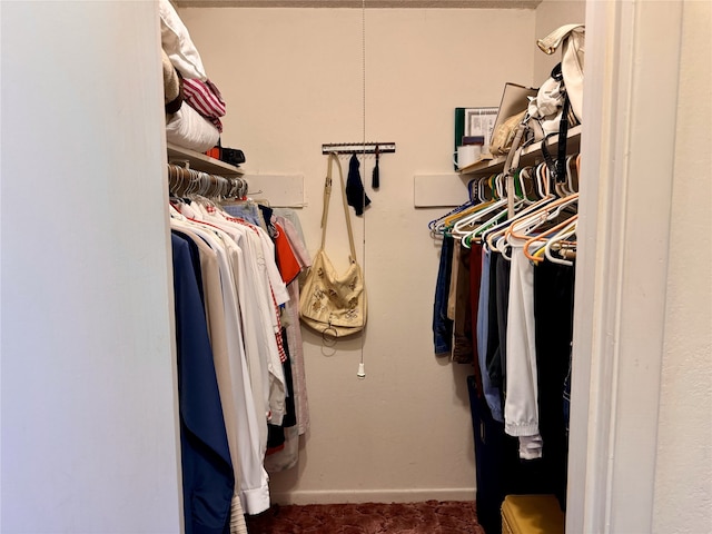 spacious closet with dark colored carpet