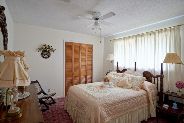 bedroom featuring a textured ceiling, a closet, dark colored carpet, and ceiling fan