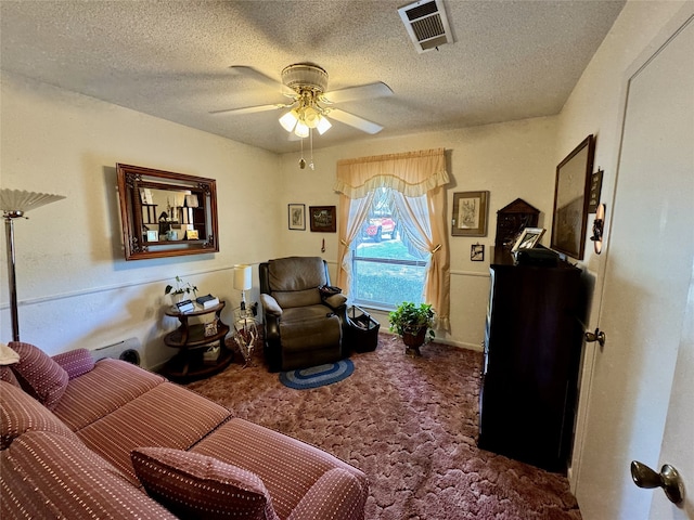 carpeted living room with ceiling fan and a textured ceiling