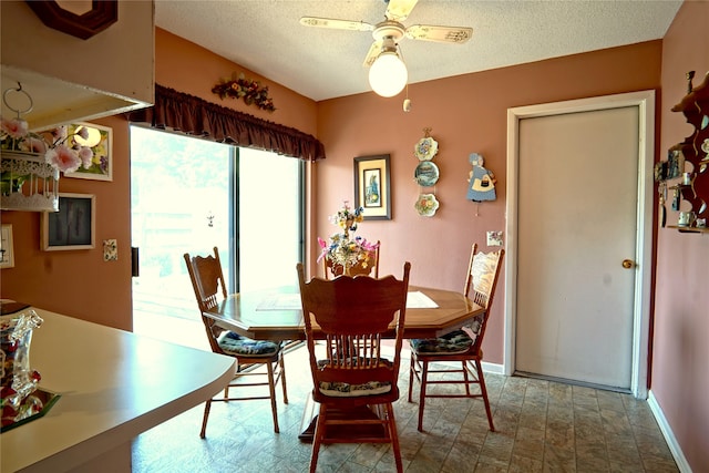 tiled dining room with a textured ceiling and ceiling fan