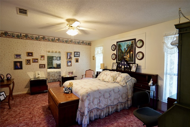 bedroom featuring dark carpet, ceiling fan, and a textured ceiling