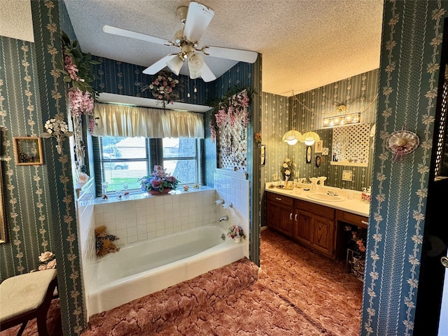 bathroom featuring a textured ceiling, ceiling fan, a bathing tub, and vanity