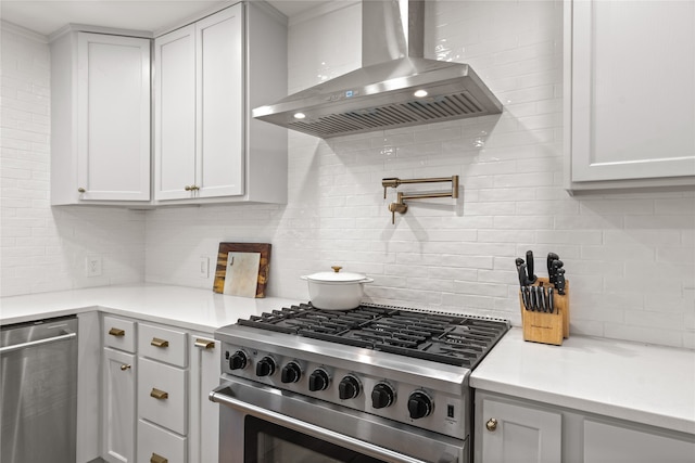 kitchen with white cabinetry, decorative backsplash, wall chimney exhaust hood, and appliances with stainless steel finishes