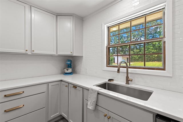 kitchen with gray cabinets, tasteful backsplash, and sink