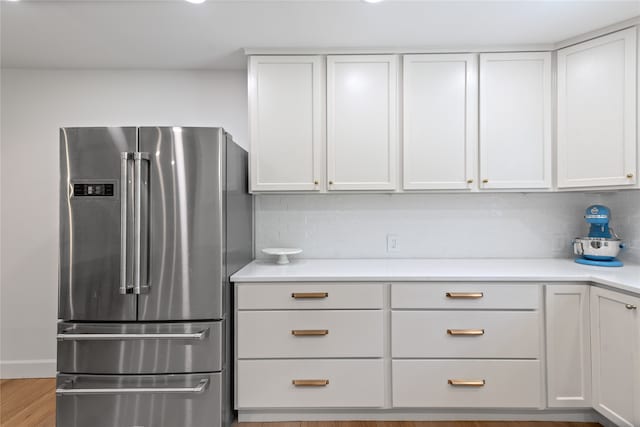 kitchen featuring white cabinets, decorative backsplash, and high end refrigerator