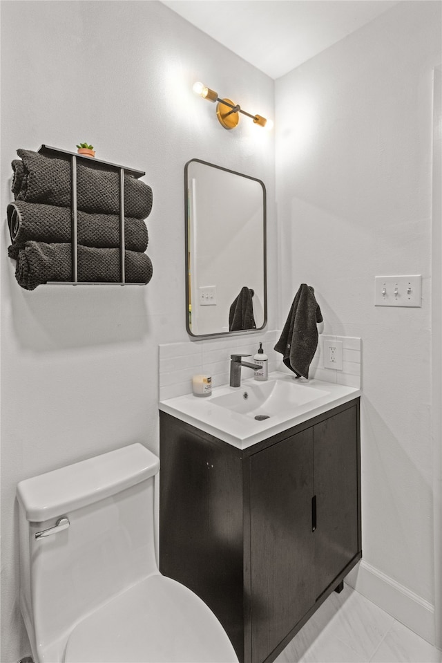 bathroom featuring tasteful backsplash, tile patterned flooring, vanity, and toilet