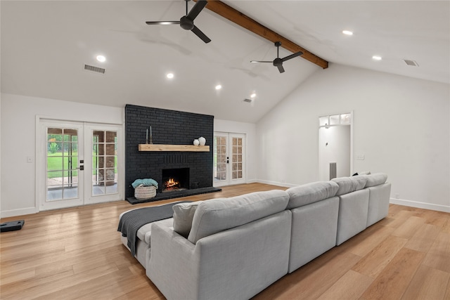 living room featuring vaulted ceiling with beams, ceiling fan, light hardwood / wood-style flooring, and french doors