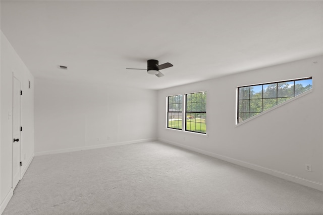 carpeted spare room featuring ceiling fan and a healthy amount of sunlight