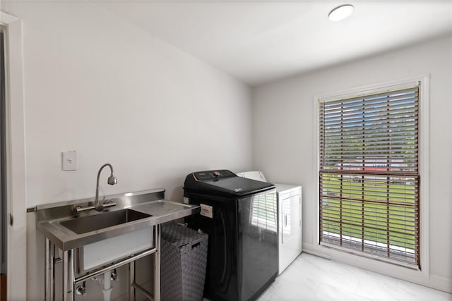 washroom featuring washing machine and clothes dryer, plenty of natural light, and sink