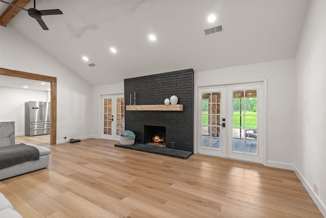 living room featuring ceiling fan, french doors, light hardwood / wood-style flooring, high vaulted ceiling, and a fireplace