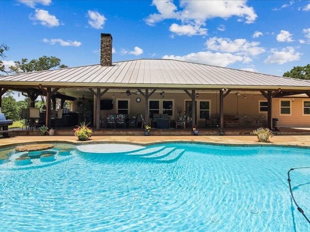 view of swimming pool with ceiling fan and a patio