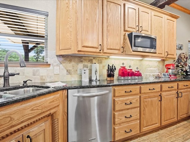 kitchen featuring dark stone counters, light hardwood / wood-style flooring, backsplash, sink, and appliances with stainless steel finishes