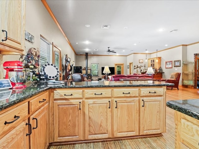 kitchen featuring ceiling fan, dark stone counters, light hardwood / wood-style flooring, and crown molding