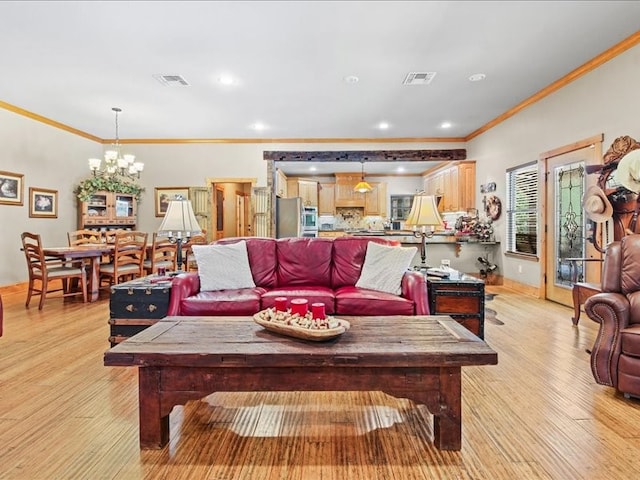 living room featuring crown molding, light wood-type flooring, and a notable chandelier