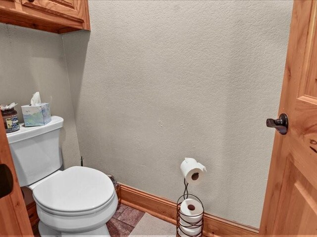 bathroom with toilet and tile floors