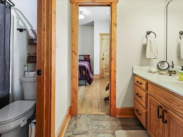 bathroom featuring tile flooring, vanity, and toilet