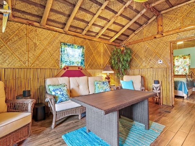 living area with wood-type flooring and vaulted ceiling