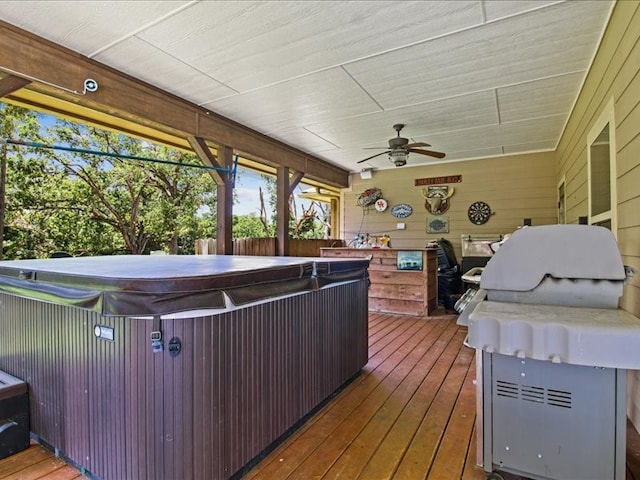 deck featuring ceiling fan and a hot tub