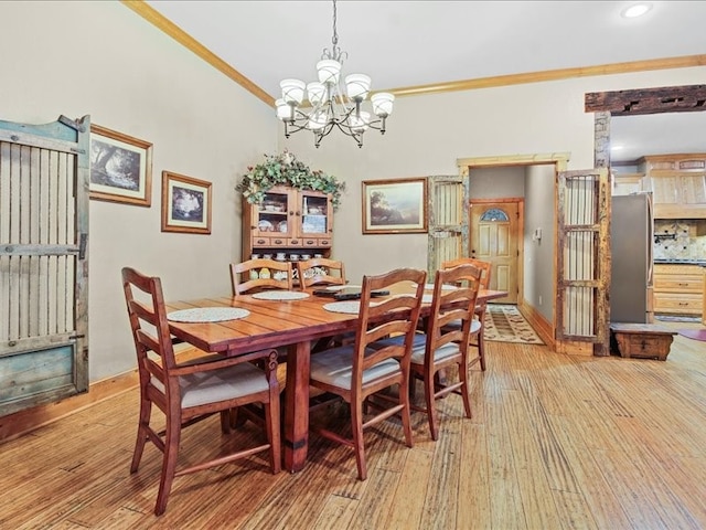 dining area featuring a chandelier, ornamental molding, and wood-type flooring