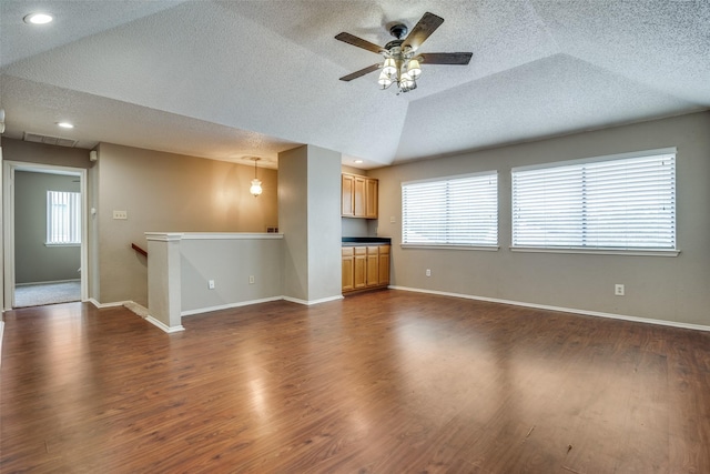 unfurnished living room with dark hardwood / wood-style floors, a healthy amount of sunlight, and a textured ceiling