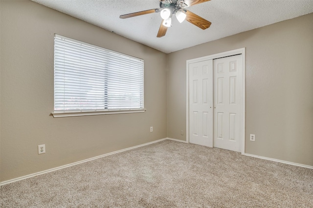 unfurnished bedroom featuring a textured ceiling, ceiling fan, light carpet, and a closet