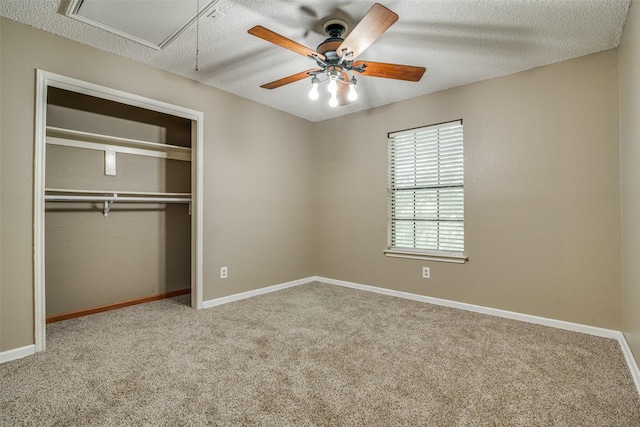 unfurnished bedroom featuring light carpet, a textured ceiling, a closet, and ceiling fan