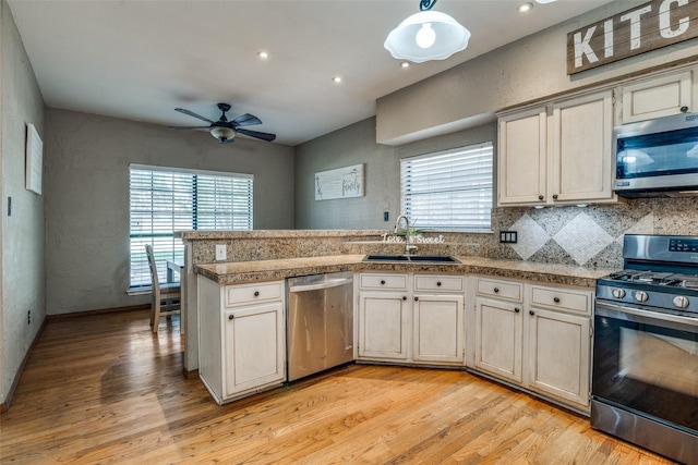 kitchen featuring a healthy amount of sunlight, light wood-type flooring, sink, and appliances with stainless steel finishes