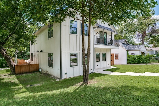 view of front of house featuring a front yard and a balcony