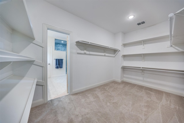 walk in closet featuring light carpet