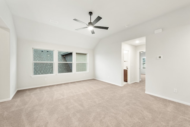 empty room featuring lofted ceiling, ceiling fan, and light carpet