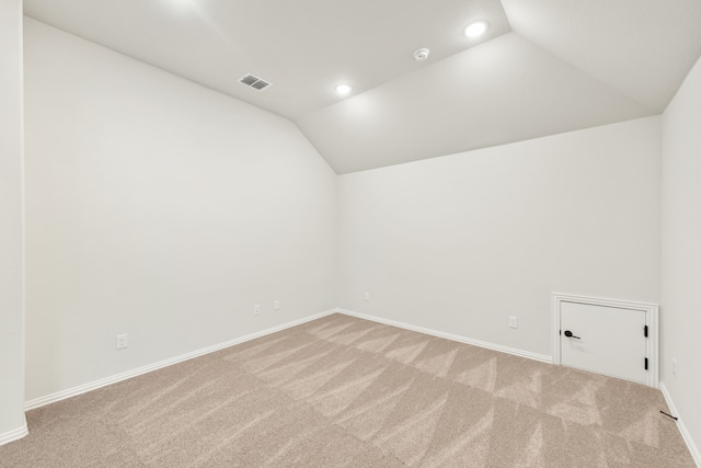 carpeted empty room featuring lofted ceiling