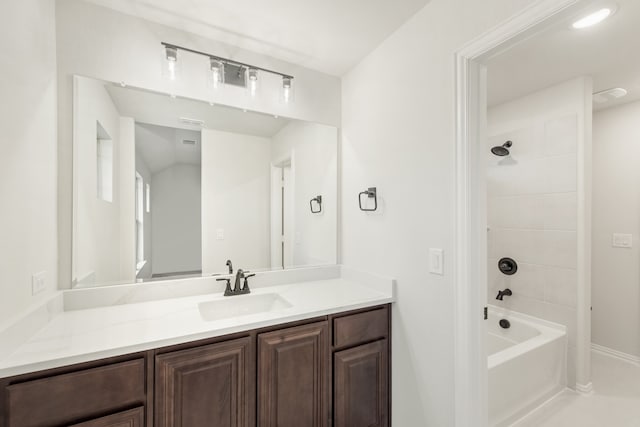 bathroom featuring tiled shower / bath and vanity