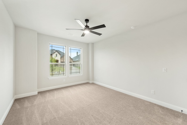 carpeted spare room with ceiling fan