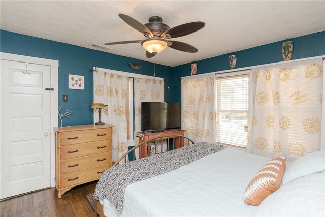 bedroom with ceiling fan and dark hardwood / wood-style flooring