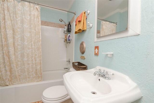 full bathroom featuring sink, shower / bath combination with curtain, and toilet