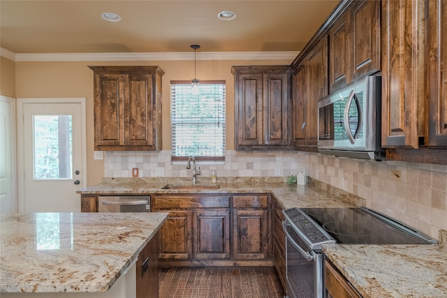 kitchen with stainless steel appliances, decorative light fixtures, light stone counters, backsplash, and sink