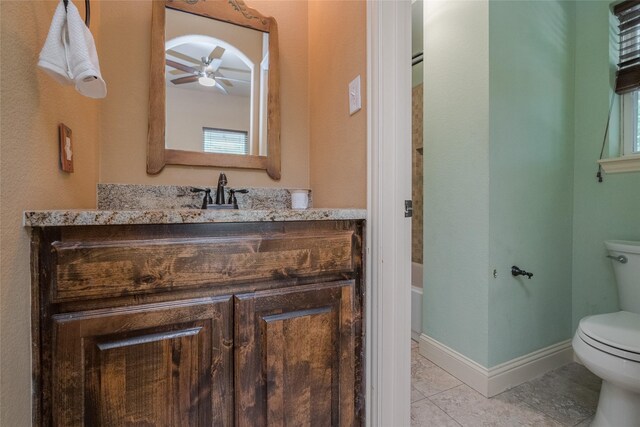 bathroom featuring tile flooring, ceiling fan, vanity, and toilet