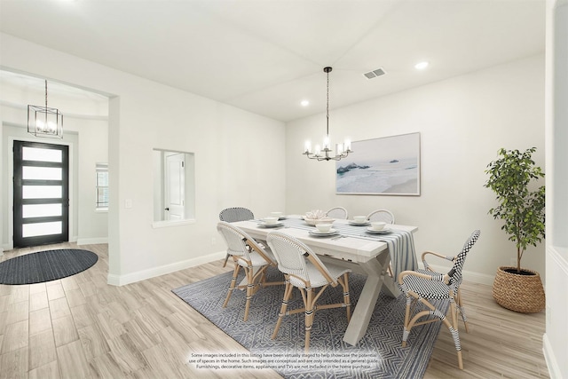 dining space featuring light hardwood / wood-style floors and a notable chandelier