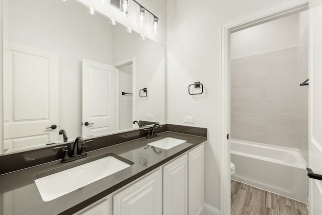 full bathroom with shower / tub combination, vanity, hardwood / wood-style floors, and toilet