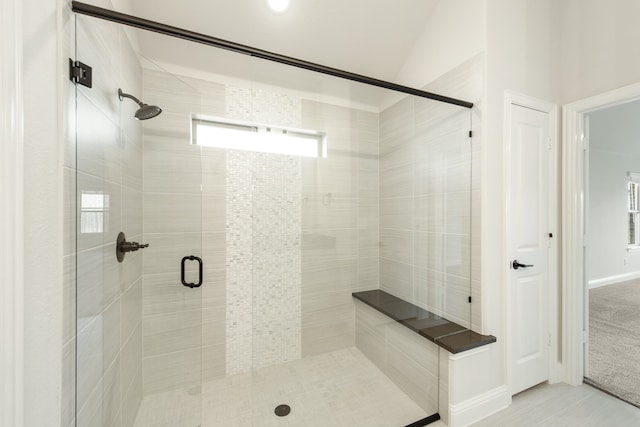 bathroom featuring vaulted ceiling and a shower with shower door