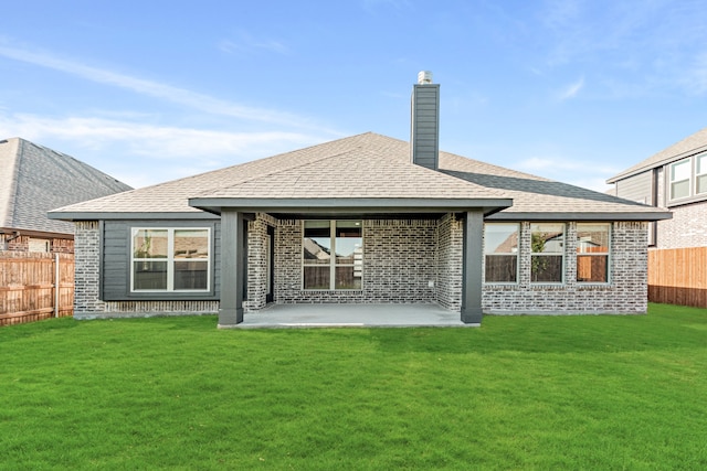 rear view of house featuring a lawn and a patio area