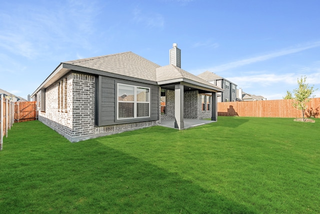 rear view of property with a lawn and a patio area