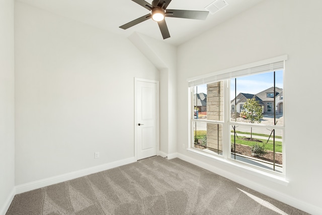 carpeted empty room featuring ceiling fan, plenty of natural light, and vaulted ceiling