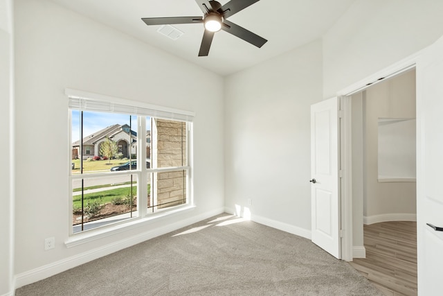 carpeted empty room featuring ceiling fan and plenty of natural light