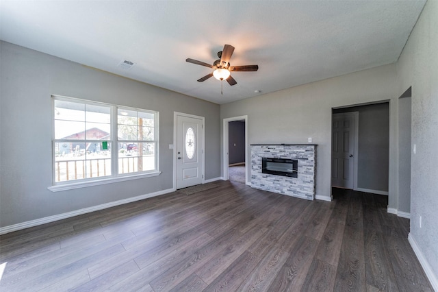 unfurnished living room with a fireplace, dark hardwood / wood-style flooring, and ceiling fan