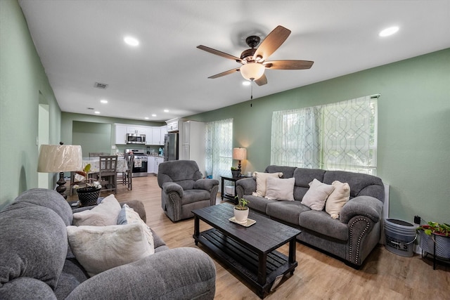 living room featuring light hardwood / wood-style floors and ceiling fan