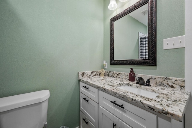 bathroom featuring toilet and vanity