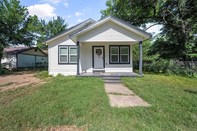 bungalow with covered porch and a front lawn