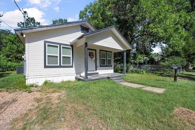 view of front facade featuring a front lawn, a porch, and central air condition unit